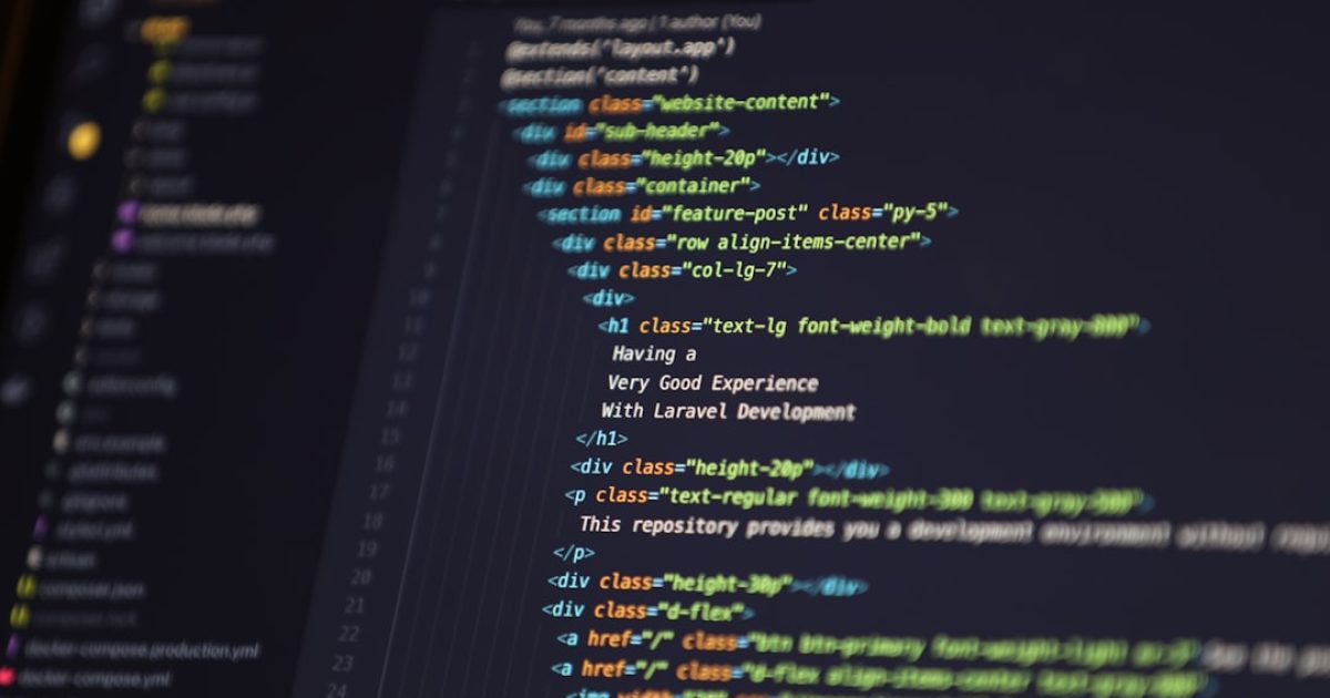 Mãos de um programador a digitar código em frente a vários monitores, exibindo frameworks JavaScript modernos e ferramentas de desenvolvimento web.