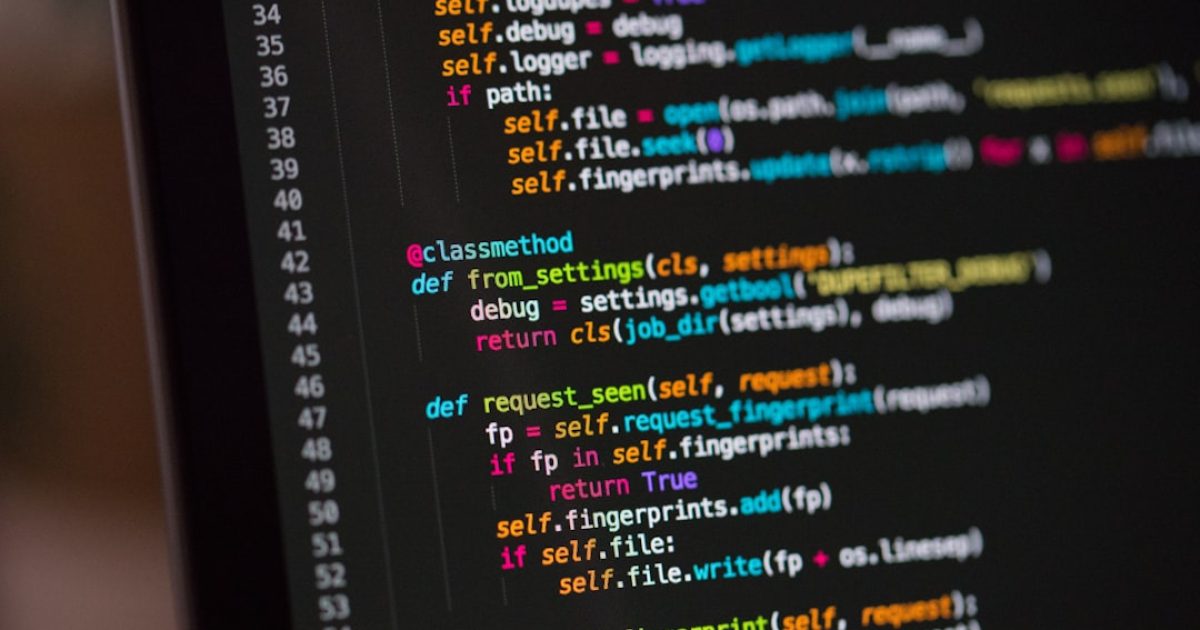 Programador a trabalhar num monitor com código PHP, simbolizando a importância de manter as versões atualizadas para segurança e desempenho web.