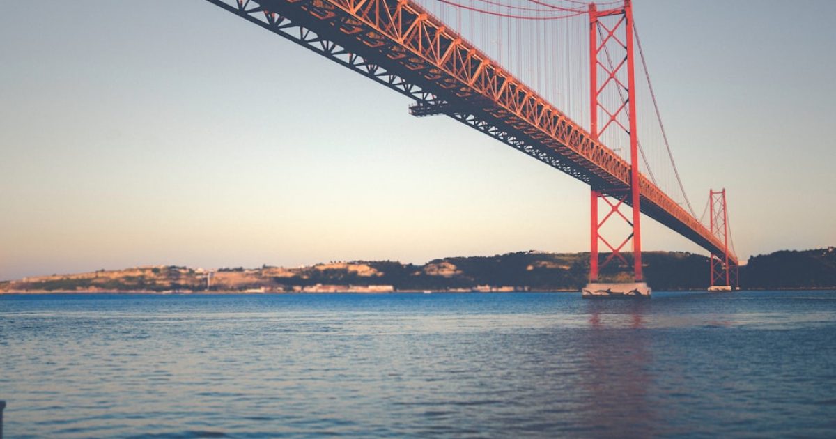 Colaborador da AlgarIT a prestar suporte técnico 24/7 por telefone a um cliente, com ecrãs de monitorização em fundo.